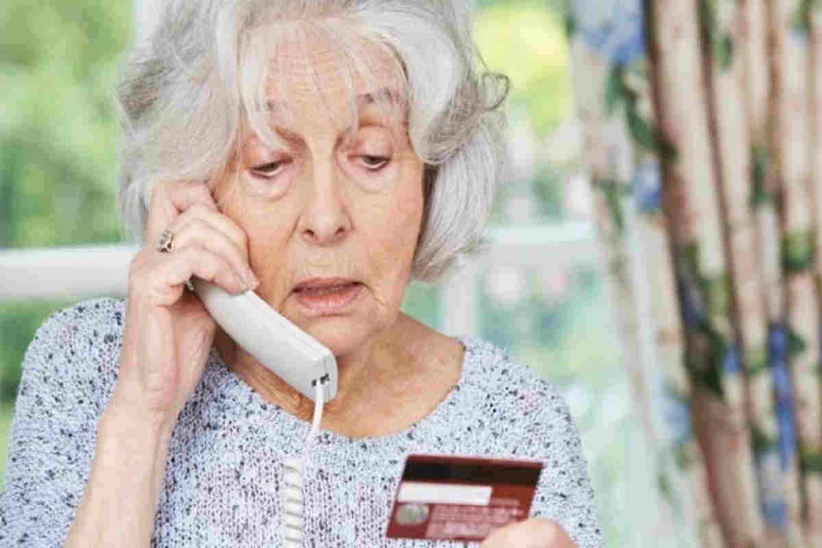 anziana al telefono con carta di credito in mano