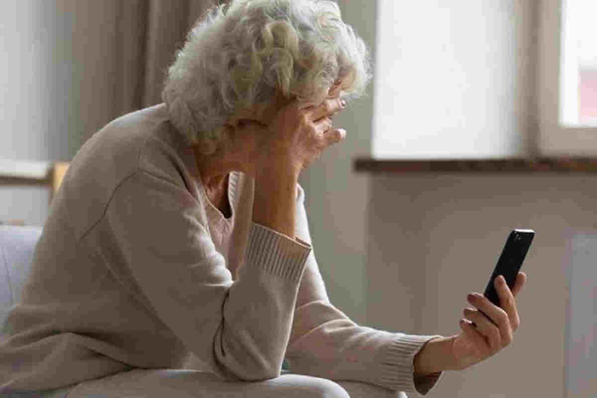 anziana che legge testo su cellulare