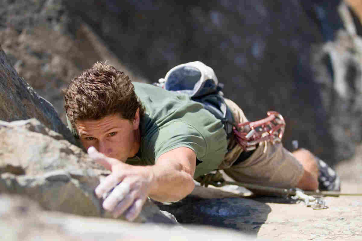 scalatore che si arrampica sulle rocce di una montagna
