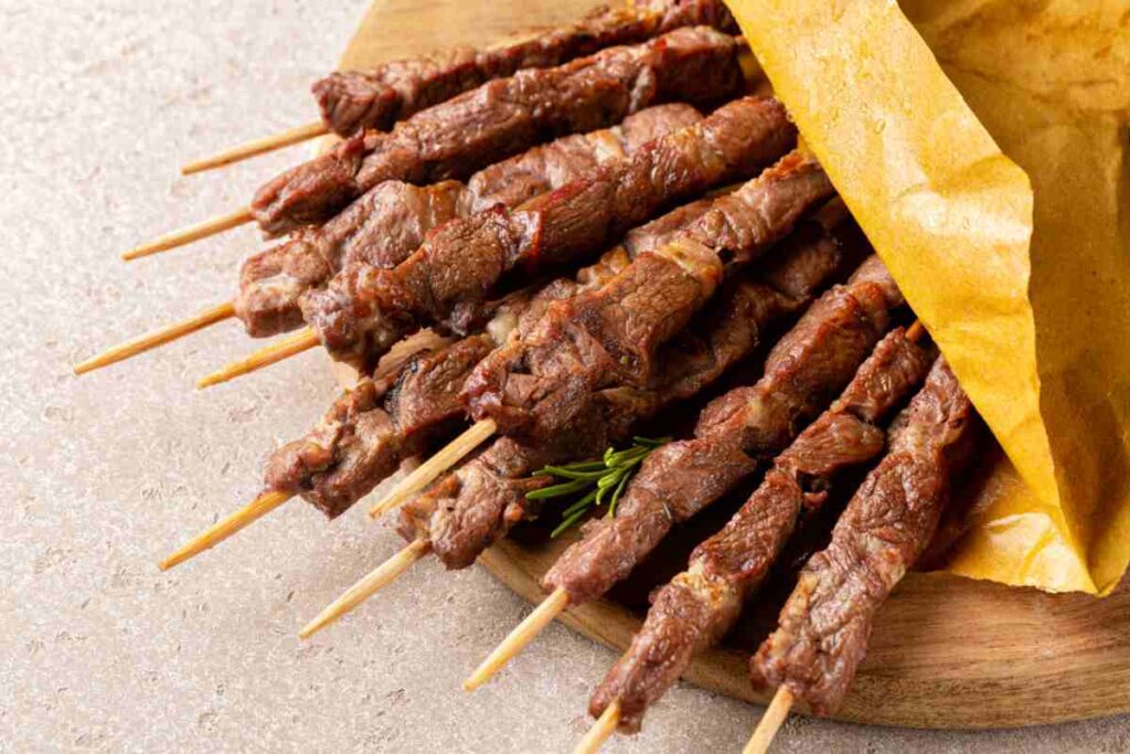 vassoio di legno con un cartoccio di arrosticini