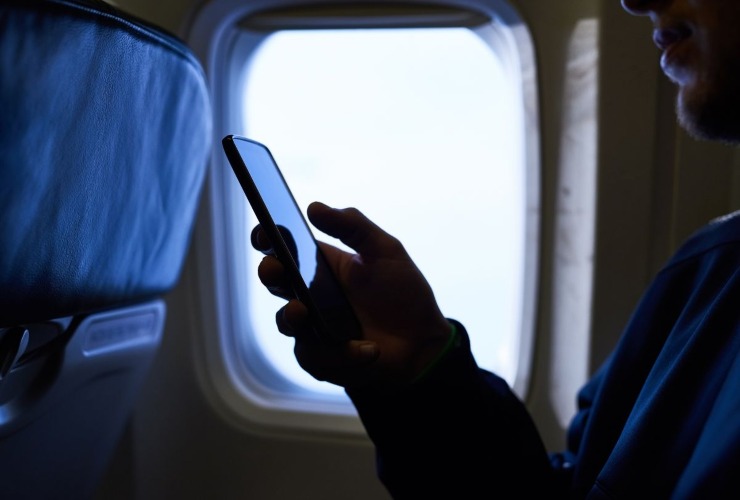 Passeggero aereo con lo smartphone in mano