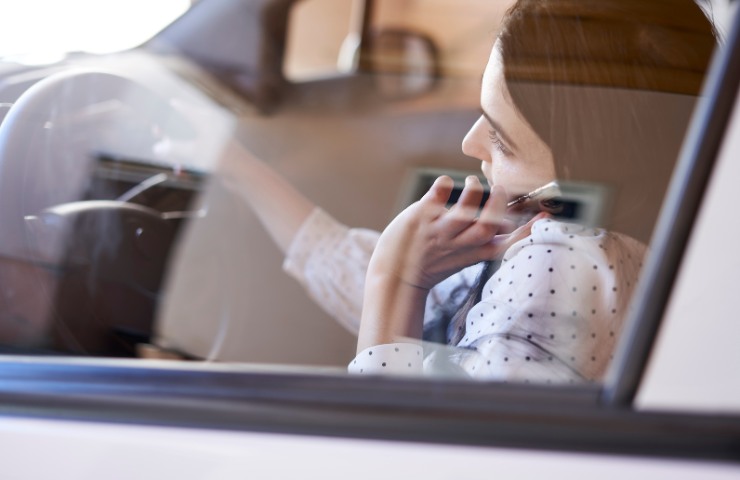 Una donna che guida parlando al telefonino