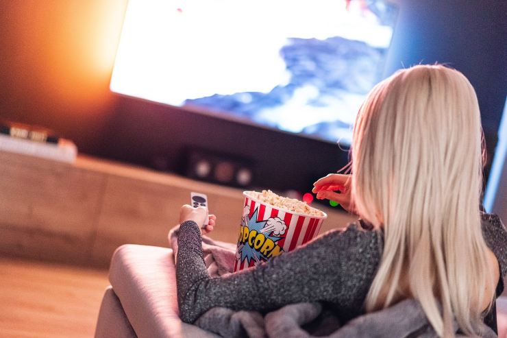 ragazza che guarda la tv con i popcorn