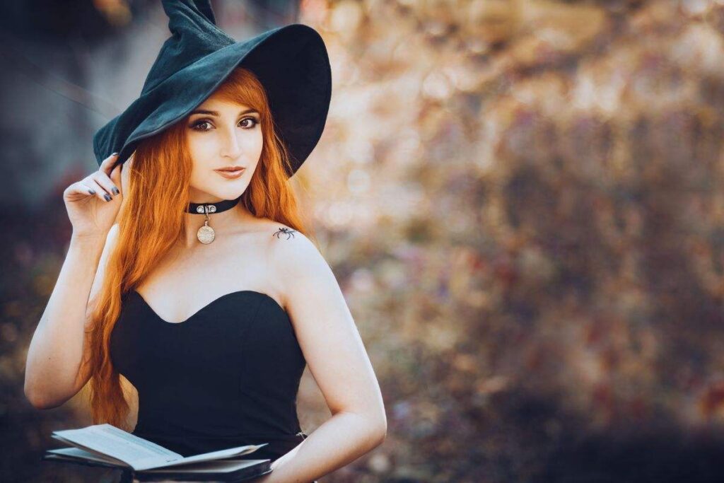 una giovane ragazza rossa vestita da strega