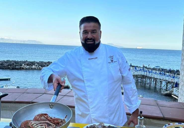 peppe di napoli in camice da chef mentre cucina all'aria aperta