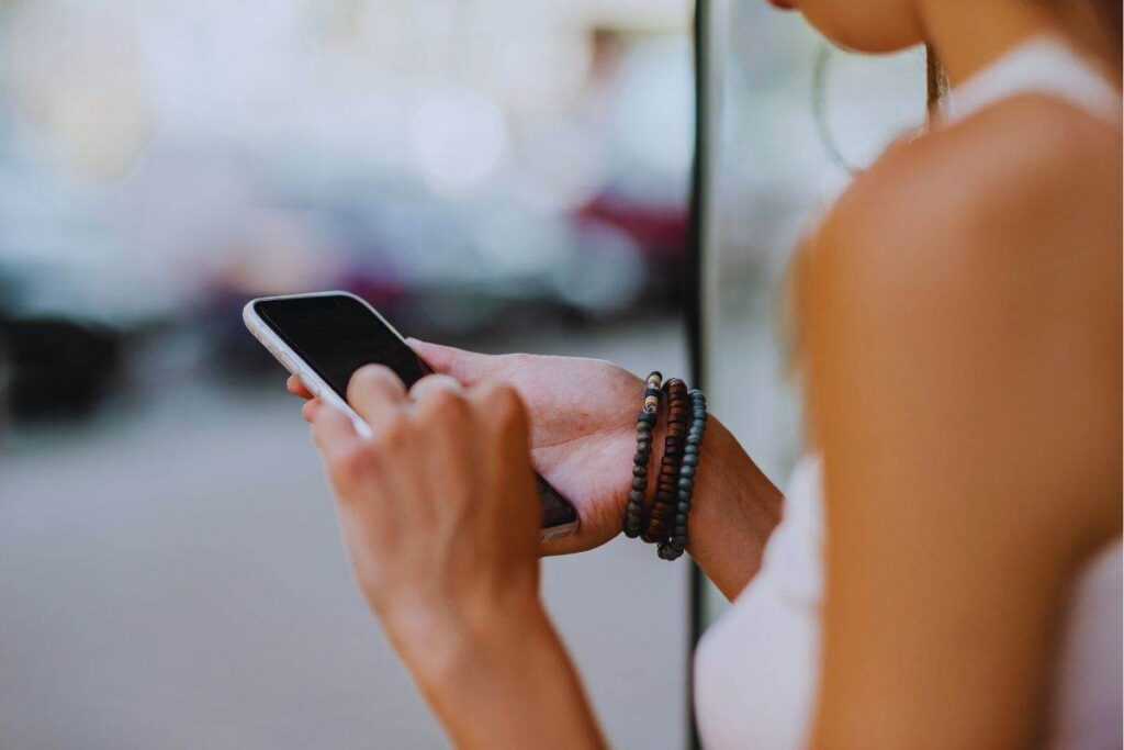 Ragazza con in mano smartphone scarico