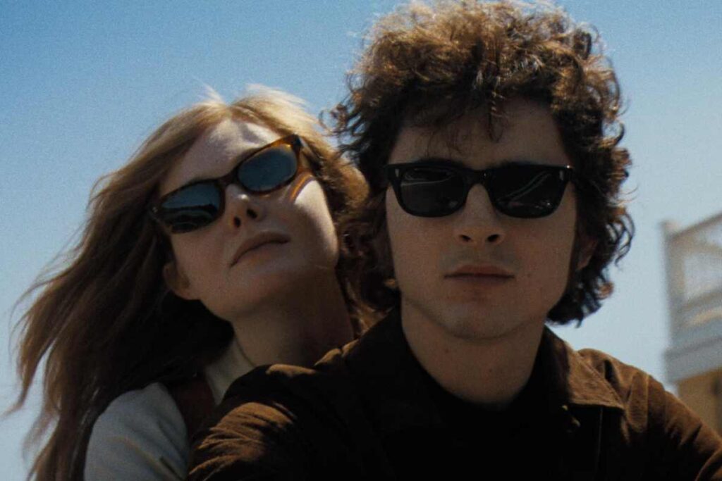 Una scena di A Complete Unknown con Timothée Chalamet e Elle Fanning in moto