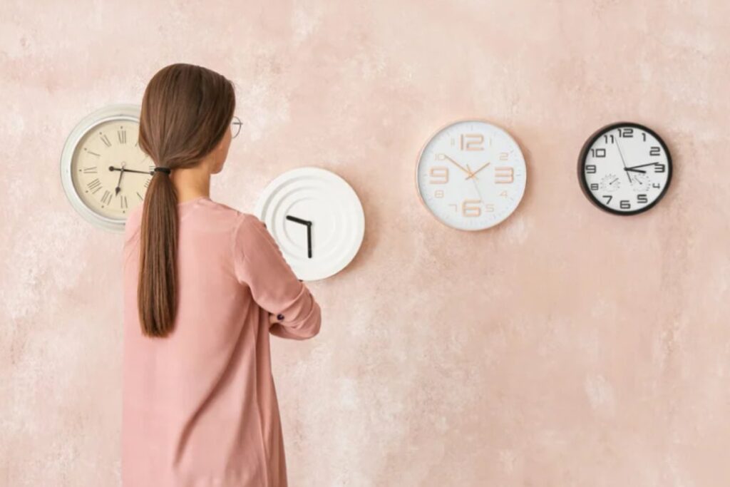 donna che guarda vari orologi alla parete