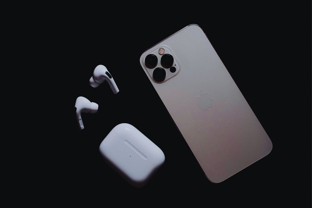 telefono apple con cuffiette su sfondo nero