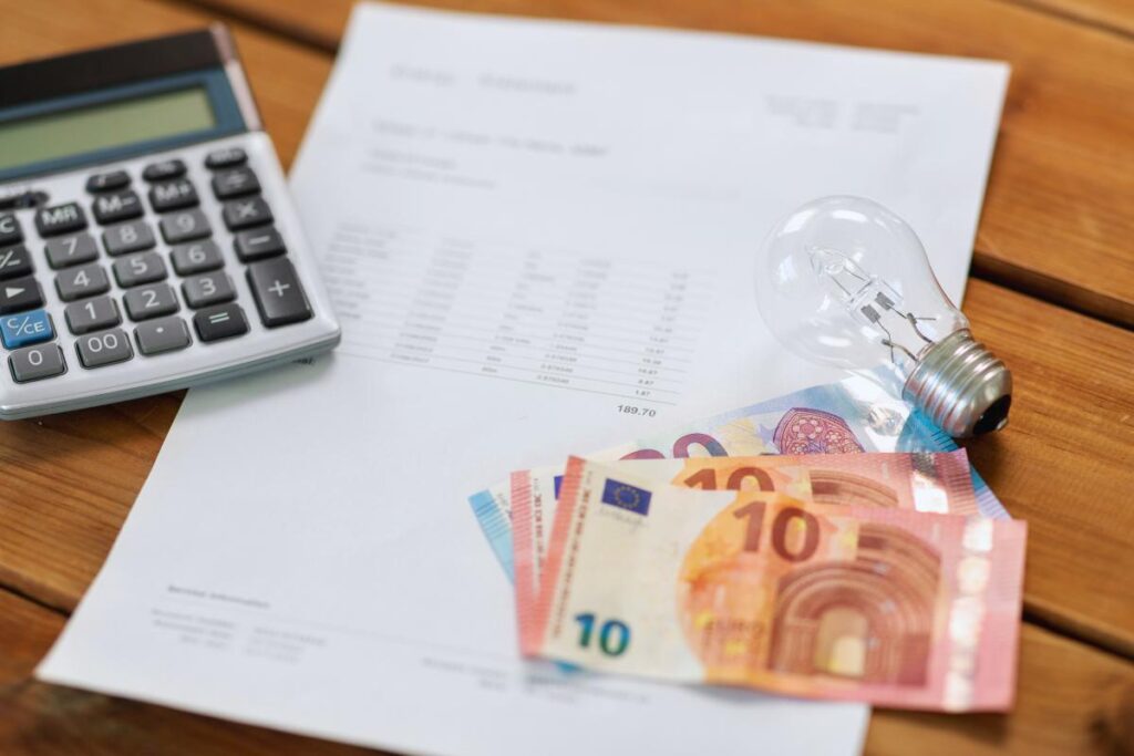 Calcolatrice con foglio, soldi e lampadina