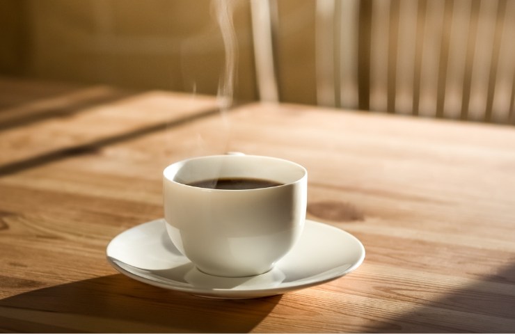 Tazzina caffè su tavolo di legno