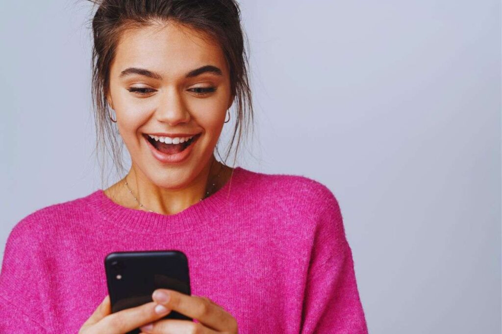 Ragazza con espressione sorpresa e cellulare