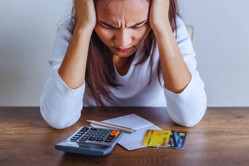 Donna disperata con carte di credito e calcolatrice