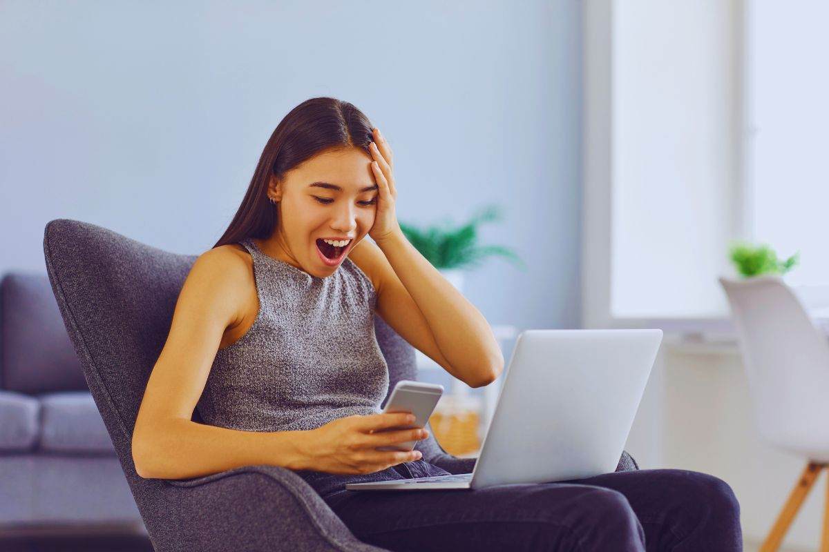 Ragazza sbalordita mentre legge qualcosa su uno smartphone
