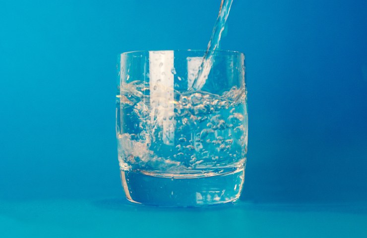 bicchiere d'acqua su sfondo azzurro