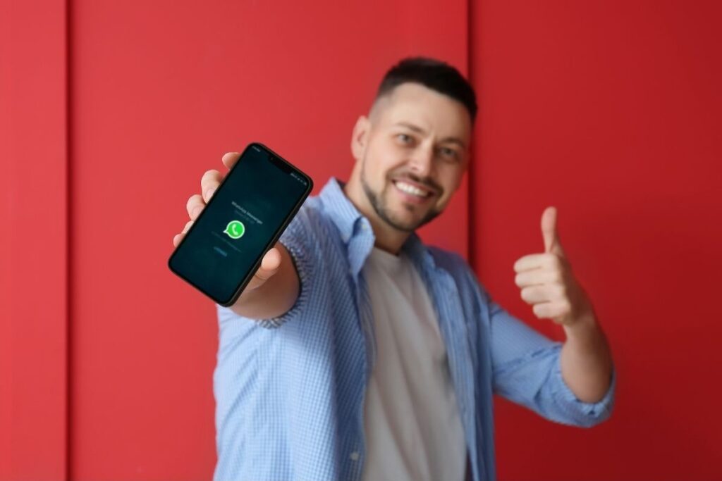 Uomo con smartphone che fa segno "ok"