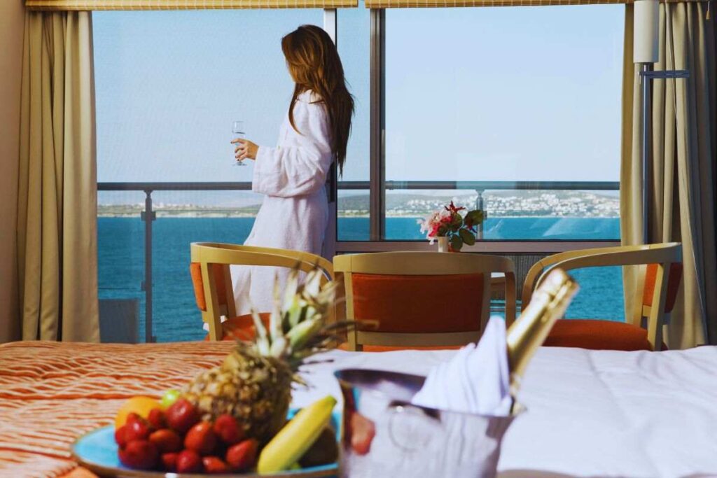 Donna in camera d'albergo alla finestra