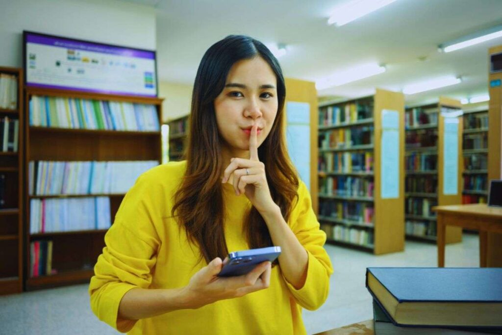 Ragazza fa gesto del silenzio con cellulare