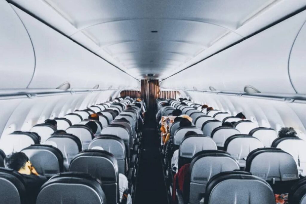 interno di un aereo con sedili e passeggeri