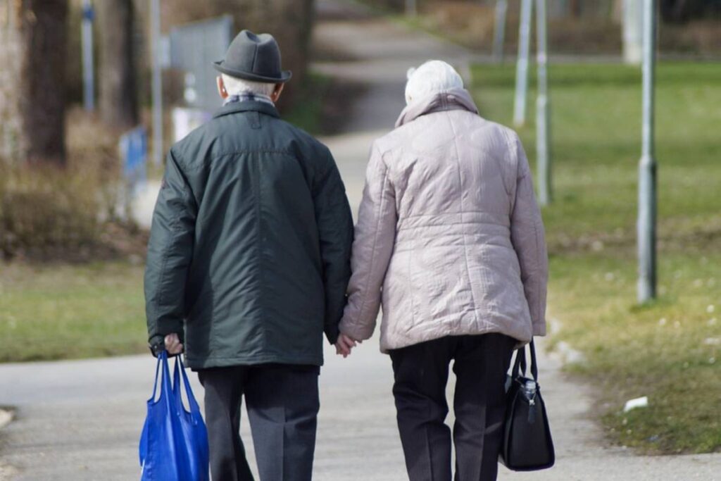 coppia di anziani che cammina con delle buste