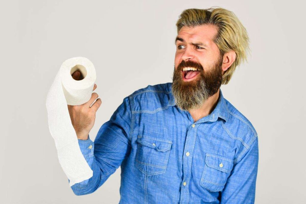 Uomo con un rotolo di carta igienica in mano