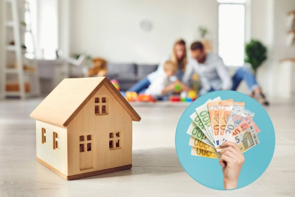 Modellino di casa con famiglia sullo sfondo e banconote