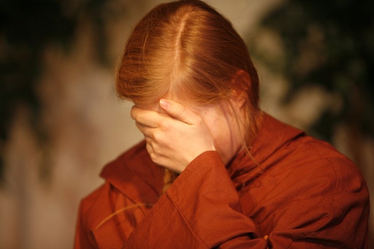 donna che si copre la faccia con una mano