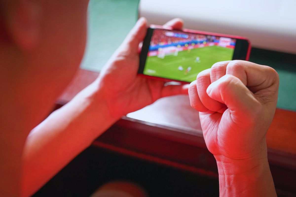 Ragazzo che guarda partita su smartphone