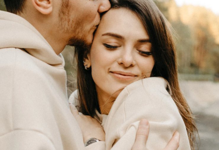 uomo che bacia donna sulla tempia 