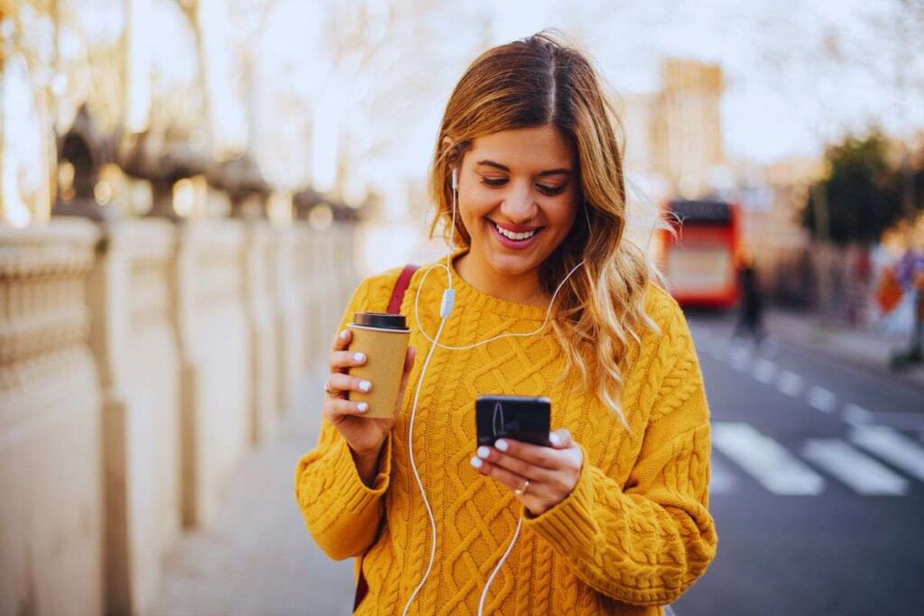 Ragazza sorridente legge messaggio su smartphone
