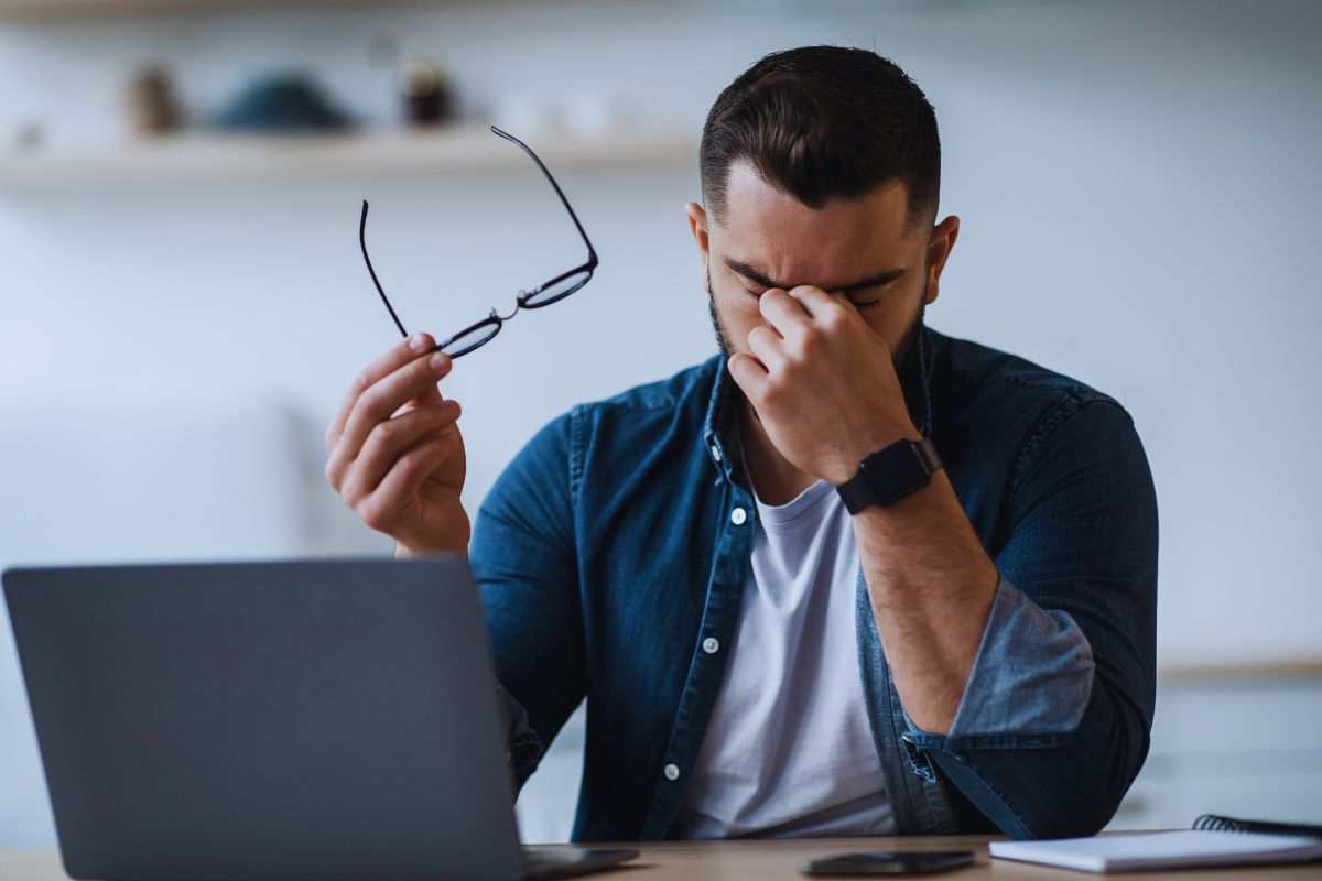 Uomo stanco per il lavoro si tiene la fronte