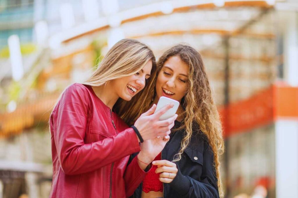 Amiche guardano qualcosa su smartphone