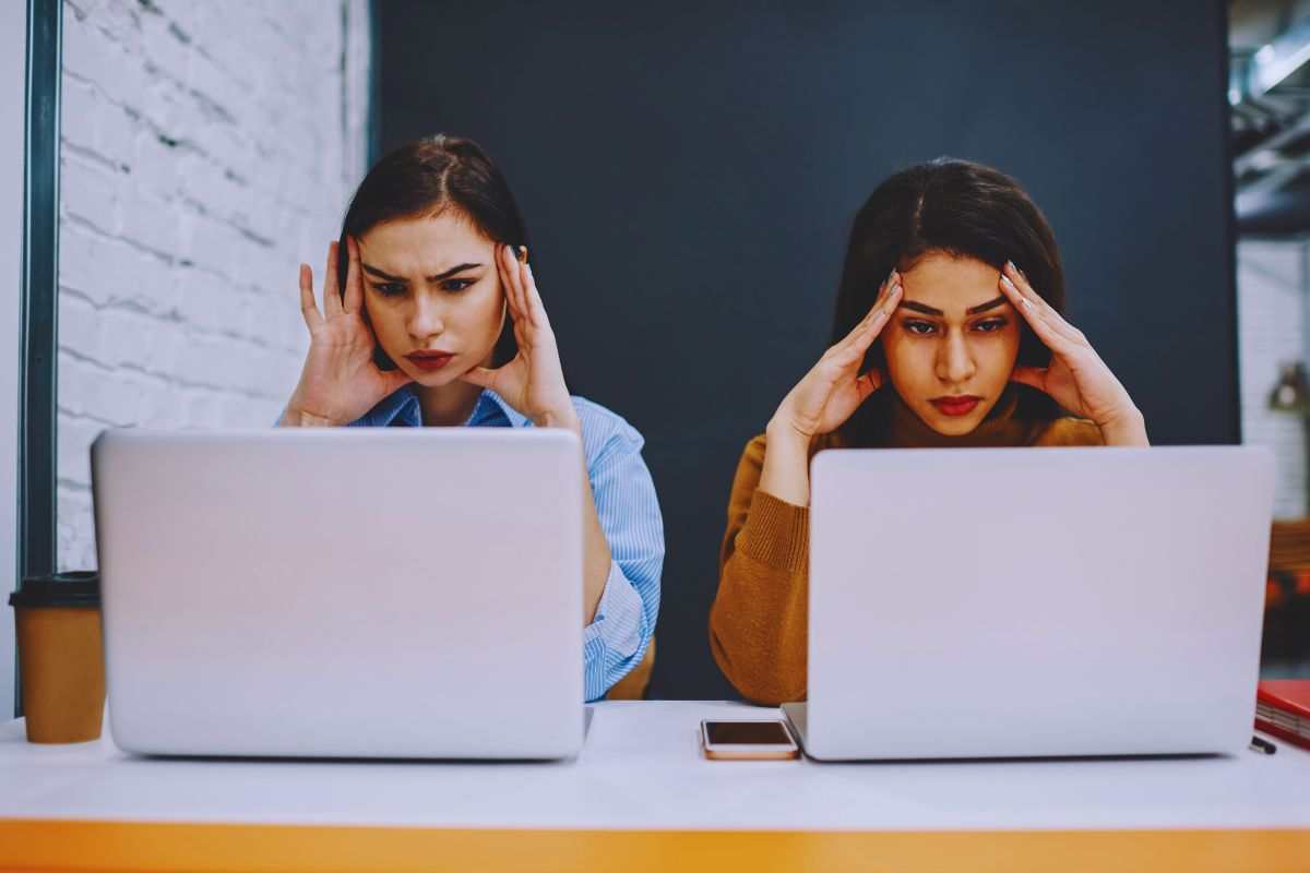 Ragazze si tengono la testa mentre guardano lo schermo del proprio PC