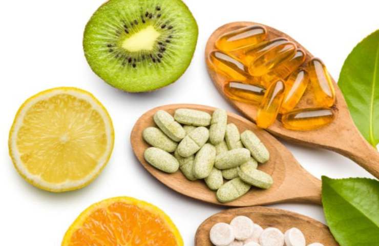 Mestoli di legno con integratori, agrumi e frutti