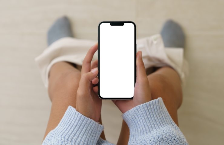 Uomo regge cellulare sul wc