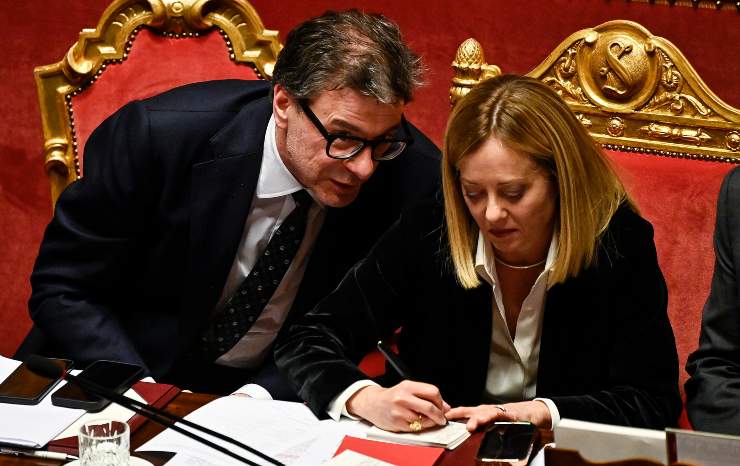 giorgia meloni scrive e accanto a lei il ministro dell'economia giorgetti