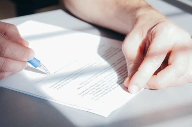 mano con penna che firma documento