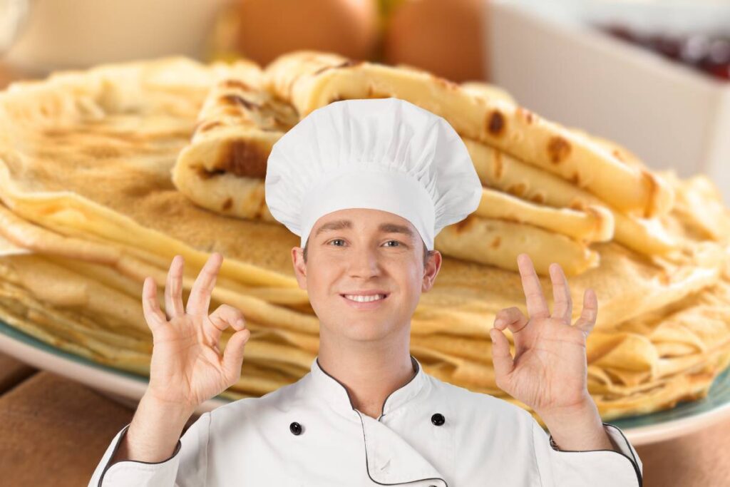 Chef in primo piano e crespelle da sfondo