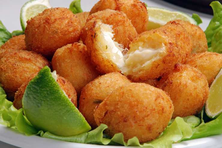 Palline fritte di baccalà su piatto con foglie verdi