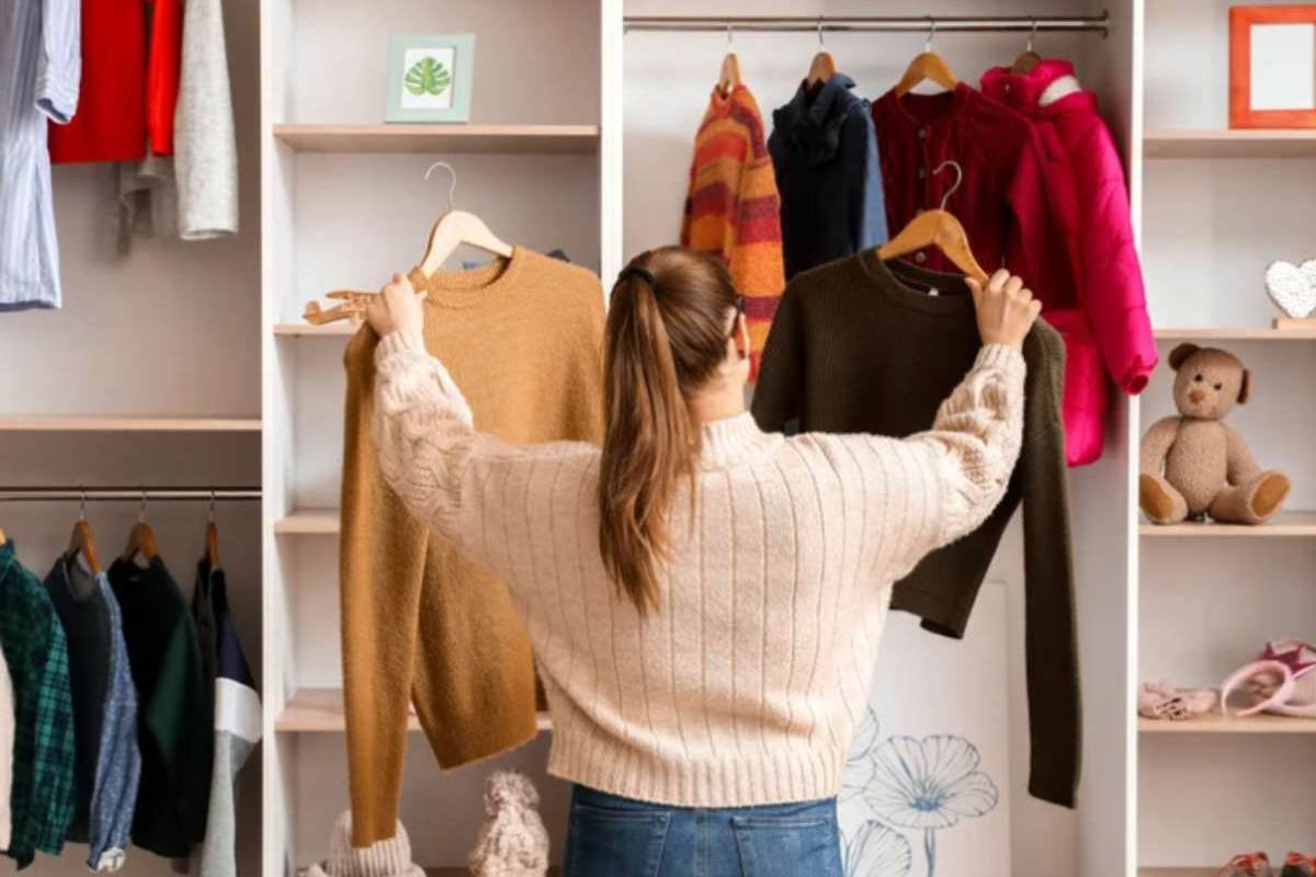 donna di spalle che sceglie vestiti