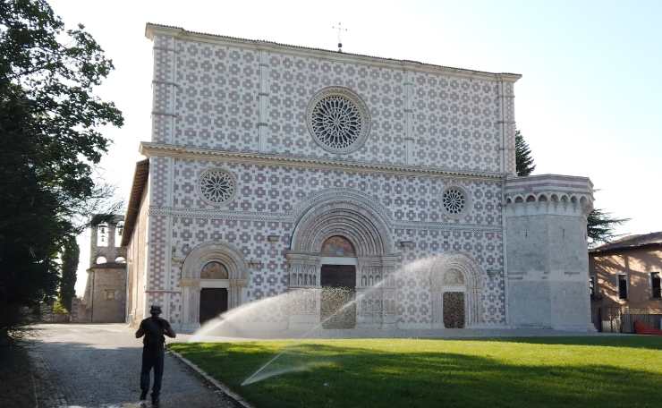una chiesa con un prato e degli innaffiatoi