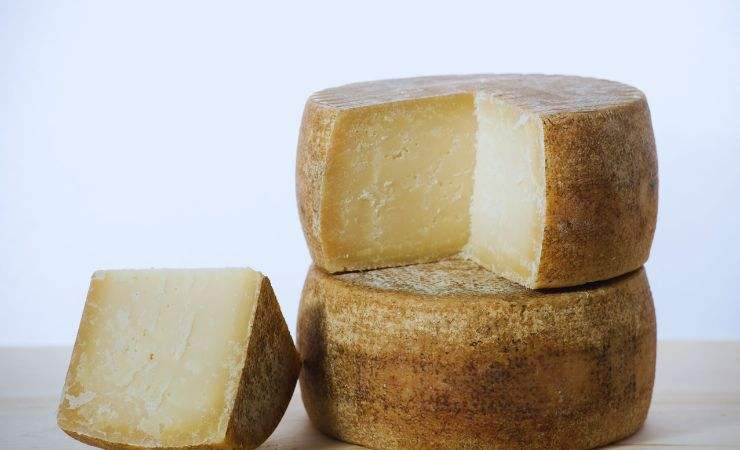 due forme di formaggio e un pezzetto tagliato