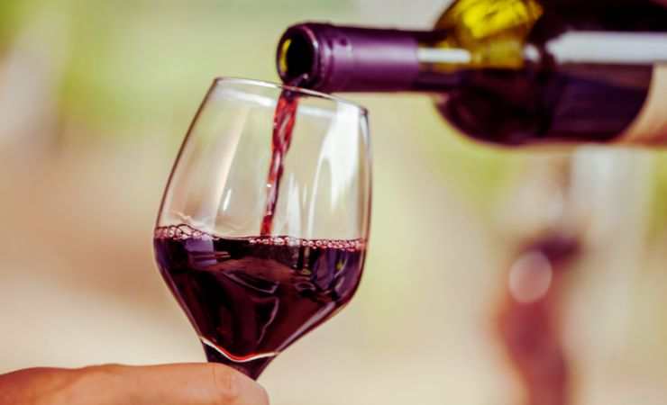 versare del vino in un bicchiere