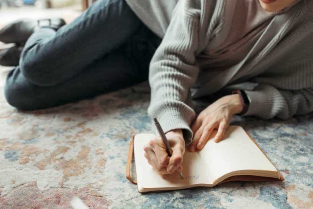 donna stesa con penna e quaderno