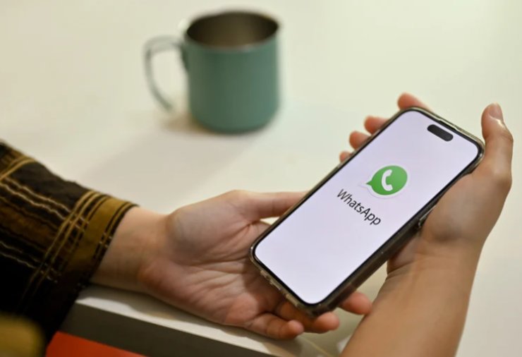 mani che reggono cellulare con logo whatsapp