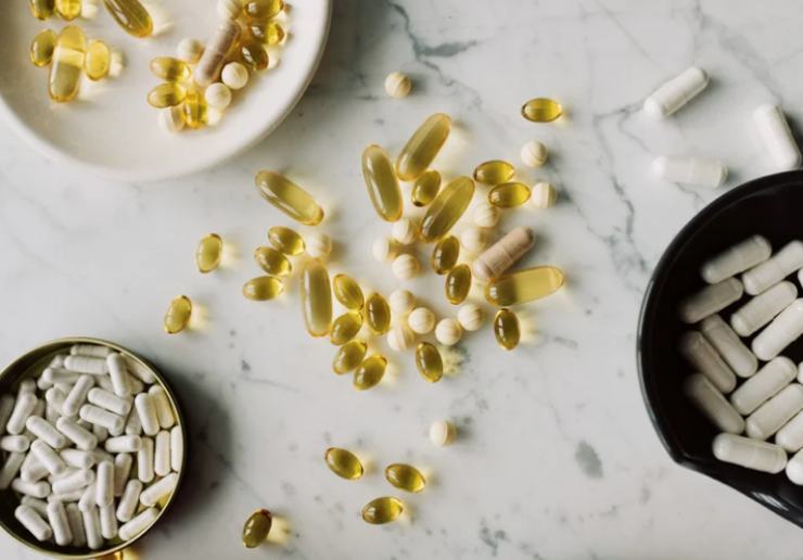 Integratori vari sparsi in ciotole e su ripiano