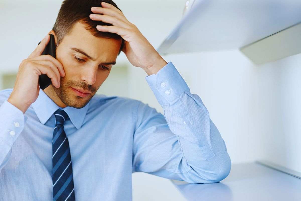 Uomo al telefono con aria preoccupata