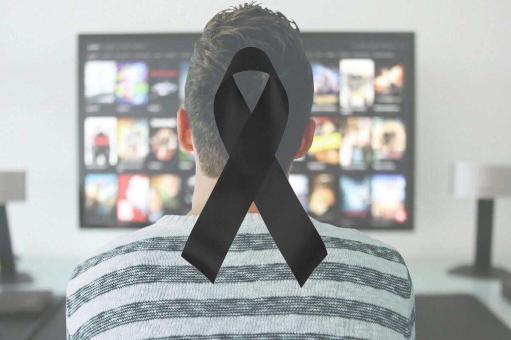 un ragazzo guarda la tv e il simbolo del lutto