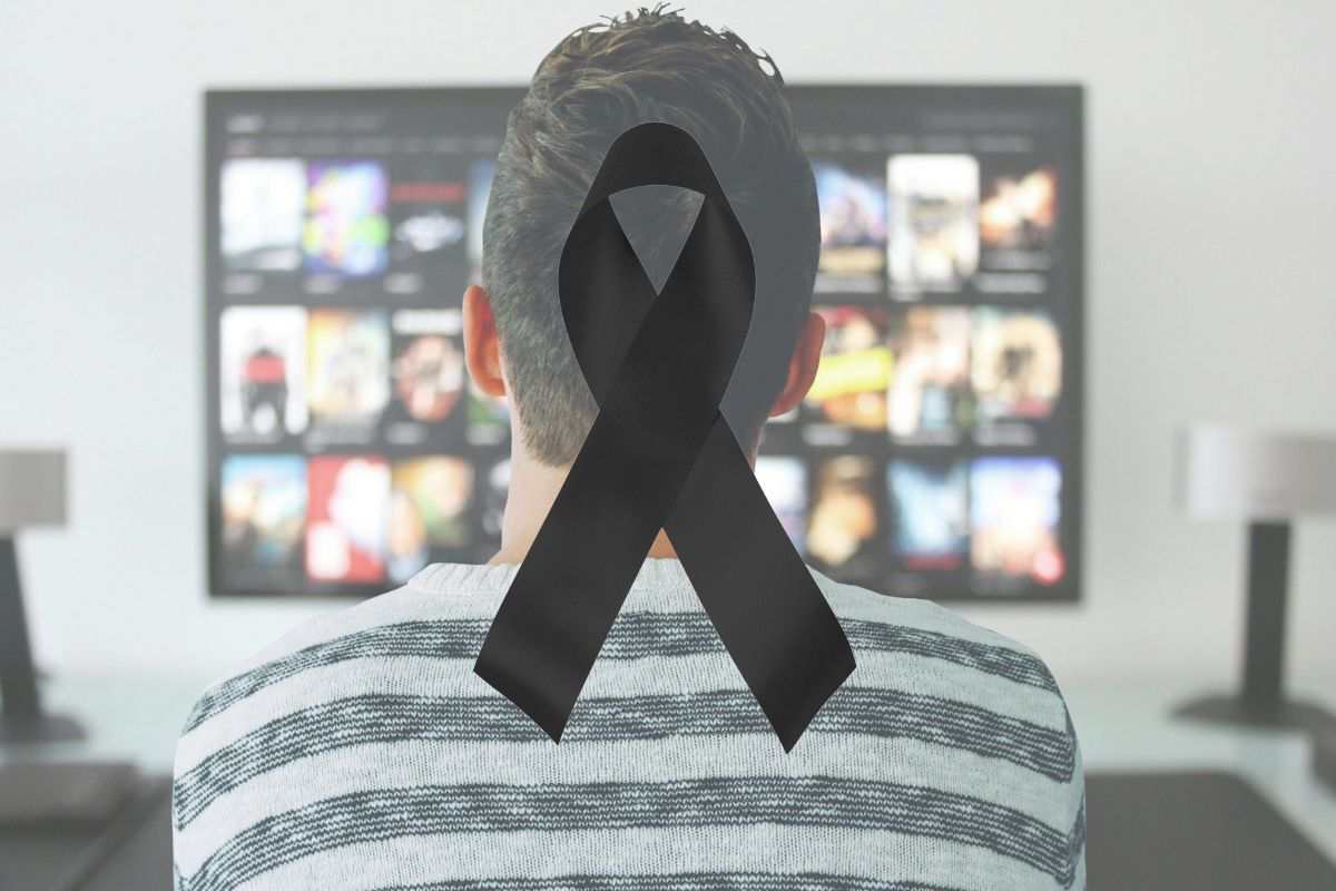 un ragazzo guarda la tv e il simbolo del lutto
