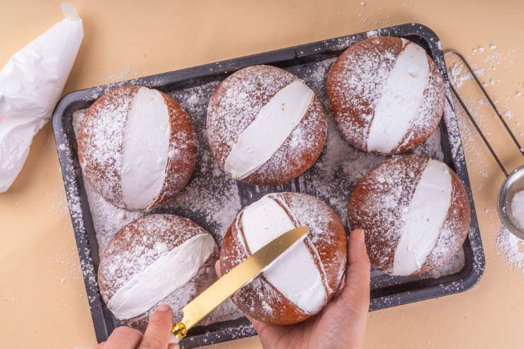 Teglia con maritozzi e donna con coltello